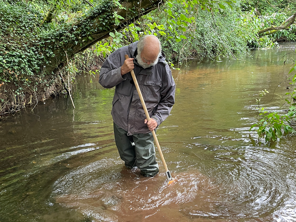 Richard Adeney in the river with a net, kick sampling